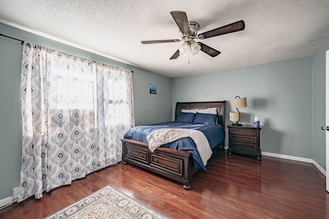 bedroom featuring dark hardwood / wood-style flooring, a textured ceiling, and ceiling fan