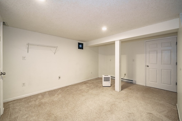 basement featuring a textured ceiling, light carpet, and a baseboard heating unit