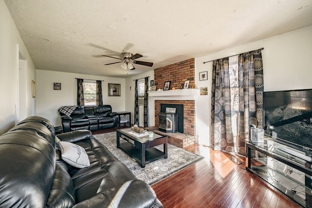 living room featuring ceiling fan, wood-type flooring, and a textured ceiling