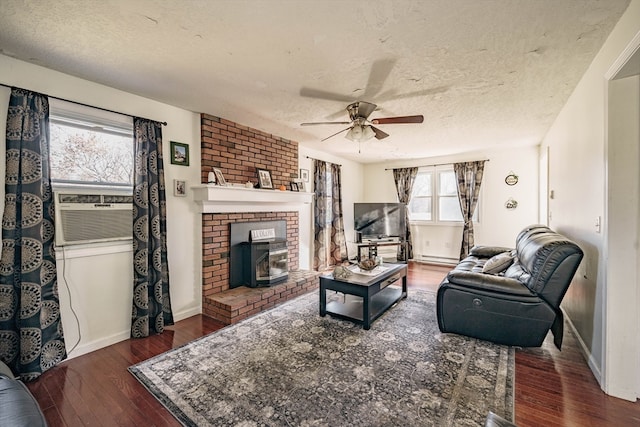 living room with cooling unit, wood-type flooring, a wood stove, a textured ceiling, and ceiling fan