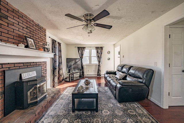 living room with dark wood-type flooring, ceiling fan, and a textured ceiling