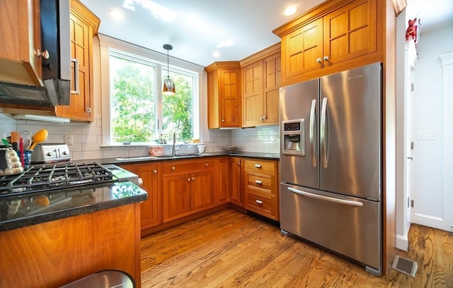 79 Henderson St, Needham, MA 02492 - kitchen with stainless steel refrigerator with ice dispenser, brown cabinets, wood finished floors, backsplash, and hanging light fixtures