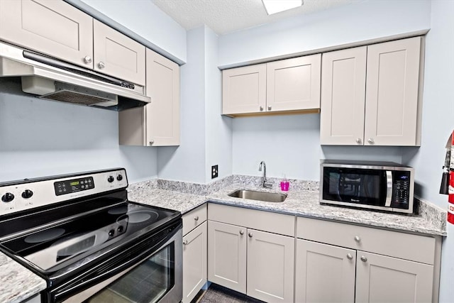250 Hammond Pond Pkwy Unit 409S, Newton, MA 02467 - kitchen featuring appliances with stainless steel finishes, under cabinet range hood, a textured ceiling, light stone countertops, and white cabinetry