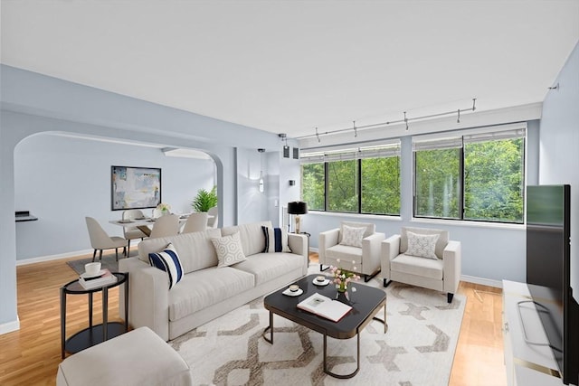 250 Hammond Pond Pkwy Unit 409S, Newton, MA 02467 - living room with arched walkways, light wood-style floors, healthy amount of natural light, and track lighting