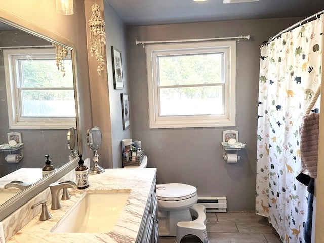 bathroom with baseboard heating, plenty of natural light, vanity, and toilet