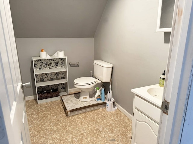 bathroom featuring vanity, lofted ceiling, and toilet