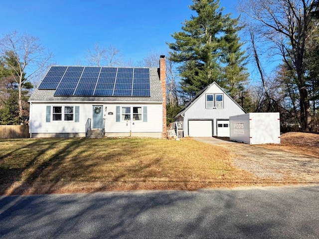 view of front of house with a front yard, solar panels, and a garage