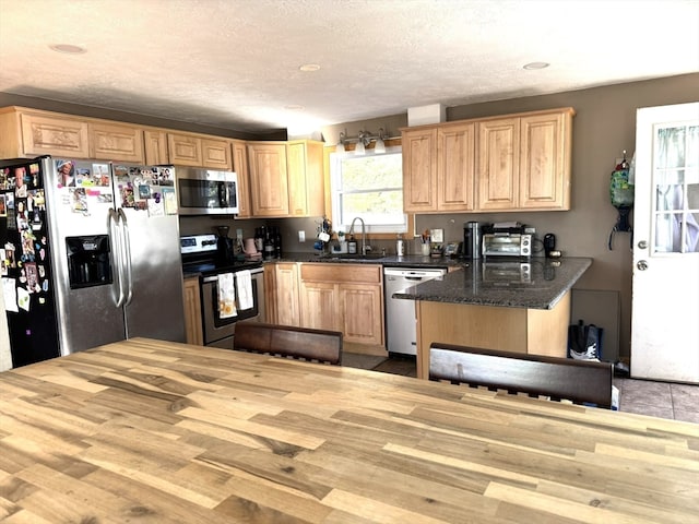 kitchen with sink, light hardwood / wood-style flooring, a textured ceiling, and appliances with stainless steel finishes