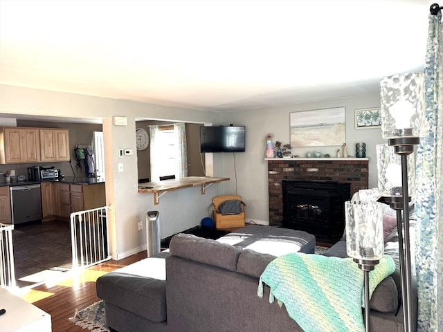 living room featuring a brick fireplace and hardwood / wood-style flooring