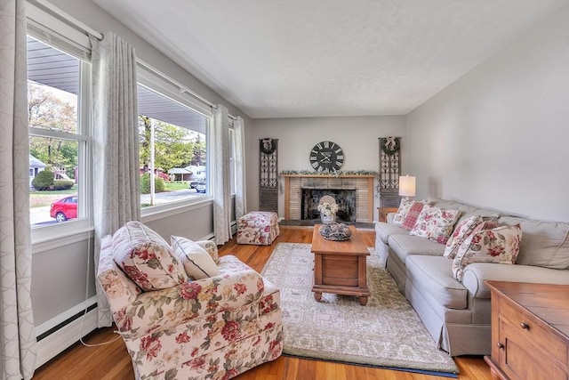 10 Briarcliff Ln, Paxton, MA 01612 - living area with a baseboard heating unit, light wood-style floors, and a fireplace