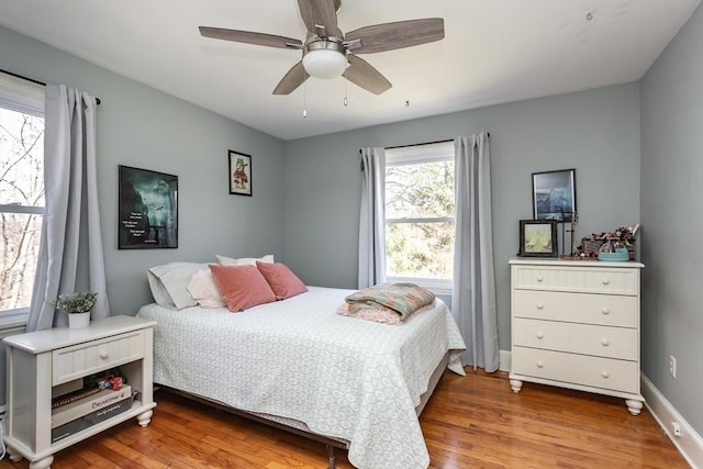 bedroom featuring a ceiling fan, wood finished floors, and baseboards