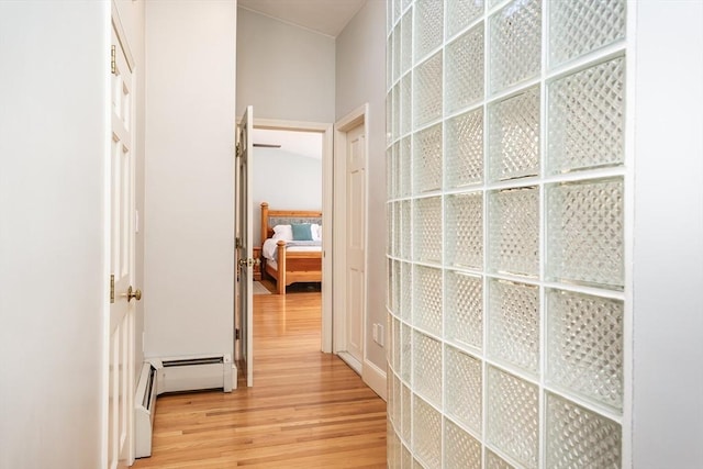 hallway with light wood finished floors and baseboard heating