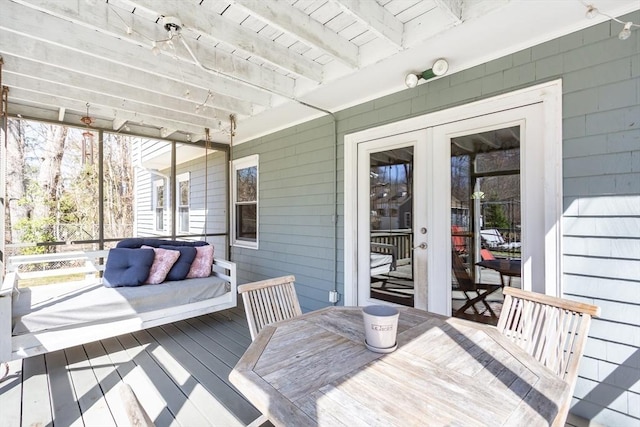 sunroom with beamed ceiling, outdoor lounge area, outdoor dining area, and french doors