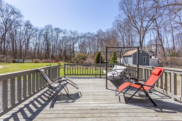 wooden deck with an outdoor structure, a lawn, and a storage shed