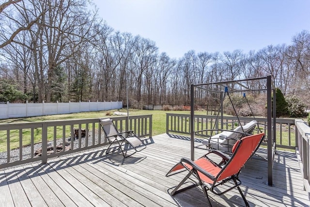 wooden terrace featuring a lawn and a fenced backyard
