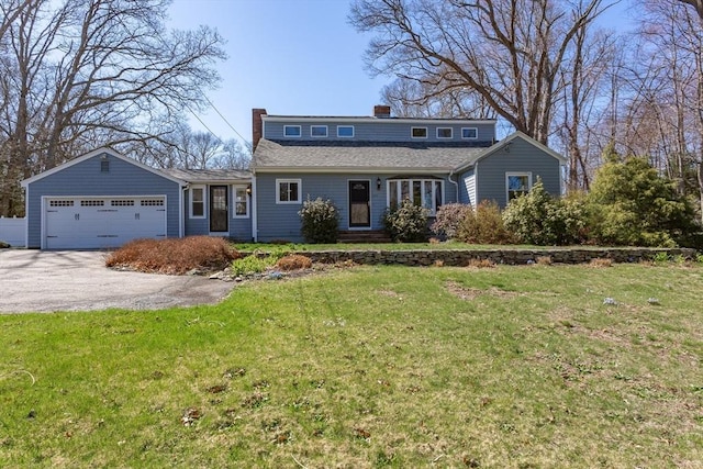 view of front of house with aphalt driveway, a chimney, a shingled roof, a front yard, and a garage