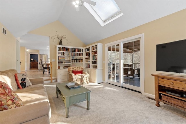 carpeted living room featuring ceiling fan, a skylight, and high vaulted ceiling