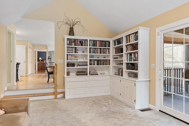 sitting room with lofted ceiling and light colored carpet