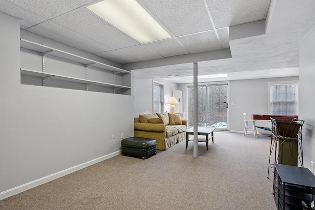 living room with carpet and a paneled ceiling