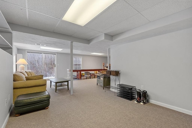 carpeted living room with a drop ceiling