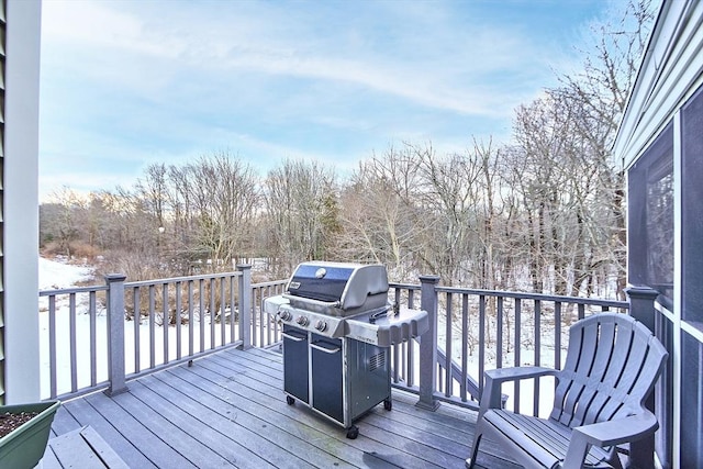 snow covered deck with a grill