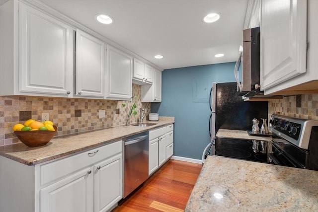 kitchen with appliances with stainless steel finishes, sink, light hardwood / wood-style flooring, and white cabinets