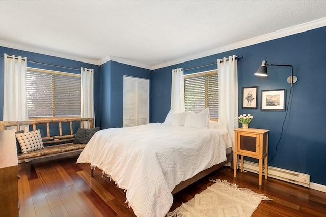 bedroom with hardwood / wood-style flooring, a baseboard radiator, ornamental molding, and a closet