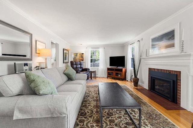 living room with light wood-style floors, a fireplace, and crown molding