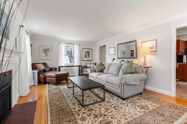 living area with crown molding, baseboards, a fireplace with flush hearth, and wood finished floors