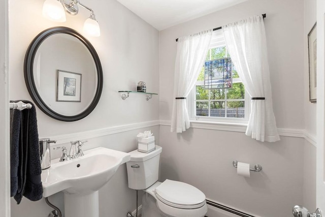 bathroom featuring a sink, toilet, and baseboard heating