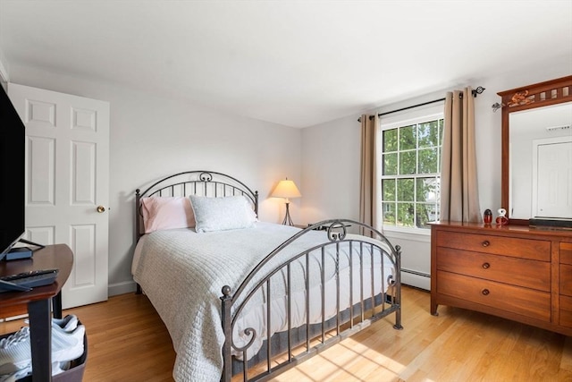 bedroom featuring light wood-style floors and a baseboard radiator