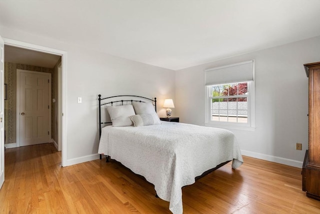bedroom with light wood finished floors and baseboards