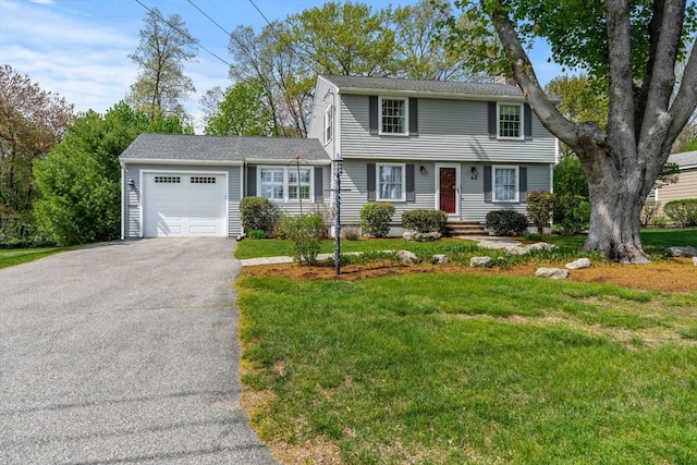 view of front of home with a garage, a front lawn, and driveway