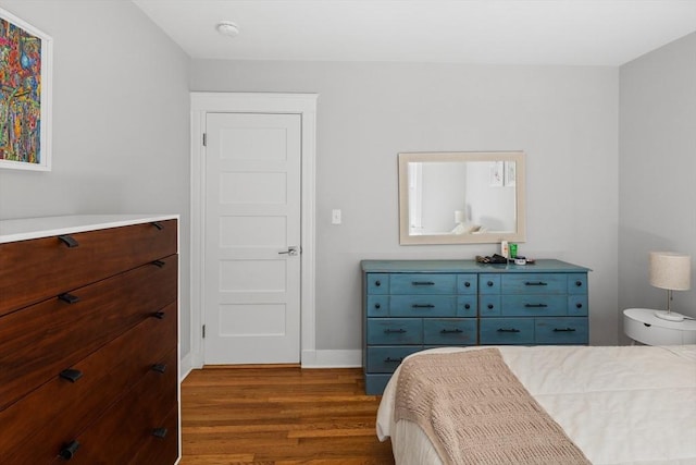 bedroom featuring baseboards and dark wood finished floors