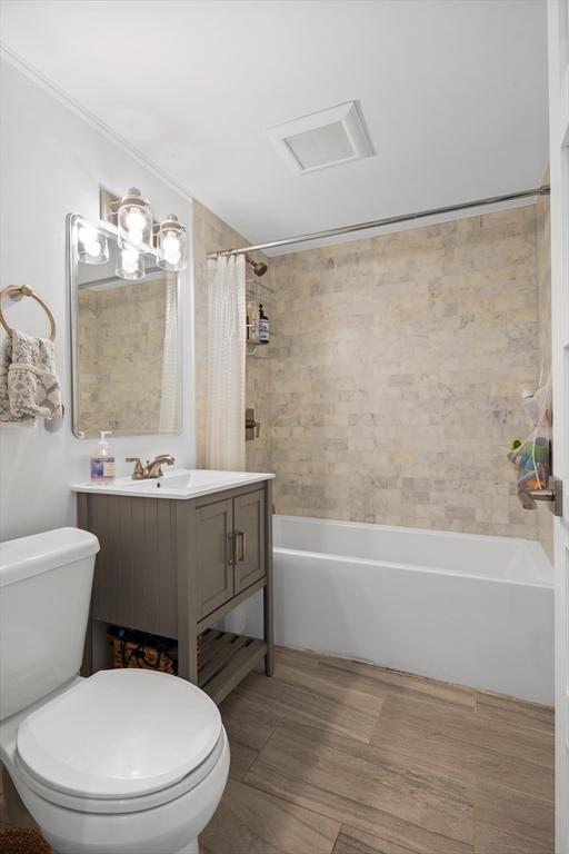 bathroom with shower / tub combo, visible vents, vanity, and toilet