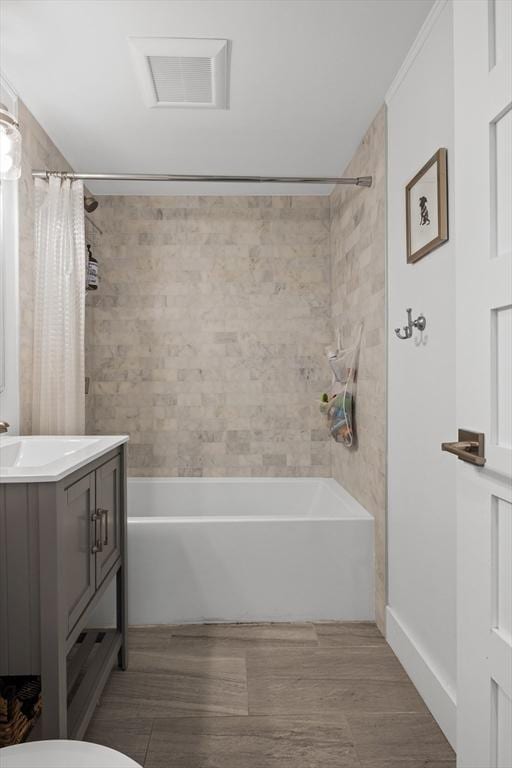 bathroom with visible vents, shower / bathtub combination with curtain, vanity, and wood finished floors