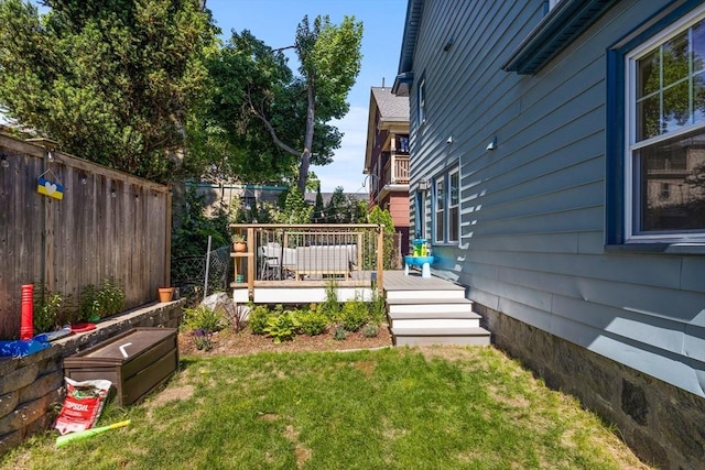 view of yard featuring fence and a deck