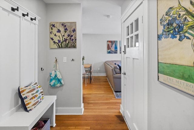 hallway featuring light wood-type flooring and baseboards