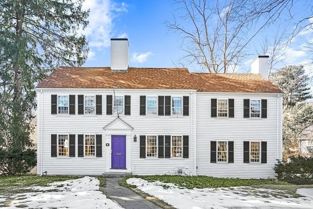 view of front of home featuring a shingled roof and a chimney