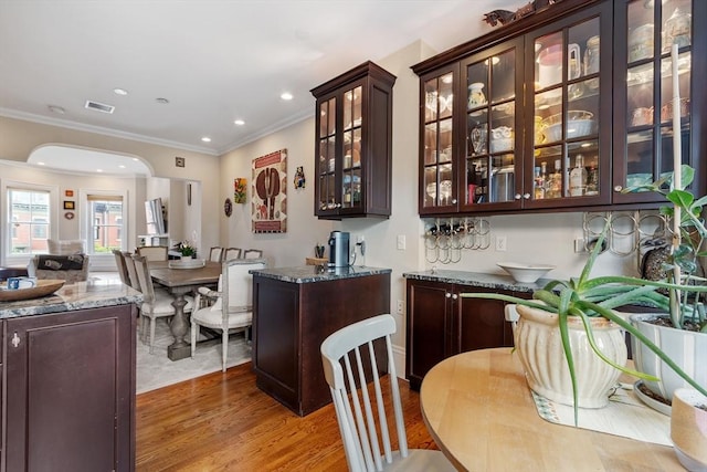 38 Concord Sq Unit 2, Boston, MA 02118 - bar with light wood-type flooring, recessed lighting, arched walkways, and crown molding