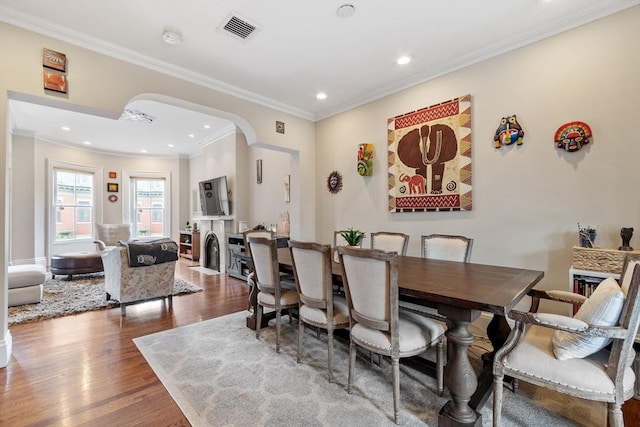 38 Concord Sq Unit 2, Boston, MA 02118 - dining space with arched walkways, dark wood-type flooring, a fireplace with flush hearth, ornamental molding, and recessed lighting