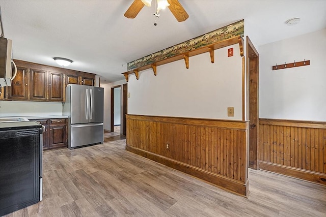61 Mattawa Cir, Orange, MA 01364 - kitchen featuring stainless steel appliances, a wainscoted wall, light wood-style floors, ceiling fan, and dark brown cabinetry