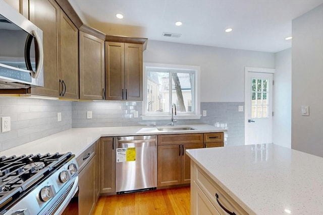 kitchen featuring a sink, a healthy amount of sunlight, visible vents, and stainless steel appliances