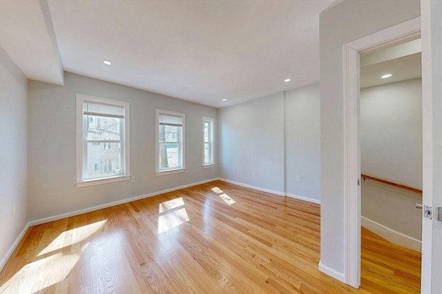 spare room featuring recessed lighting, baseboards, and wood finished floors