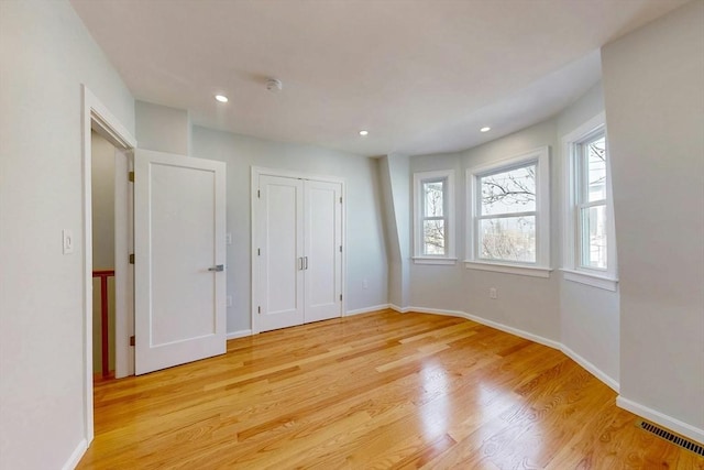 unfurnished bedroom featuring recessed lighting, visible vents, light wood-style flooring, and baseboards