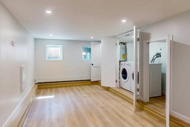 laundry room with water heater, laundry area, a baseboard heating unit, and light wood-style floors