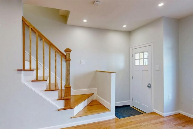 entryway with stairs, recessed lighting, wood finished floors, and baseboards