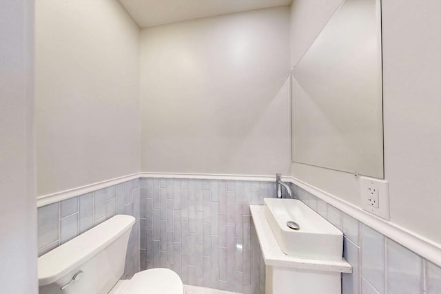 bathroom featuring toilet and a wainscoted wall