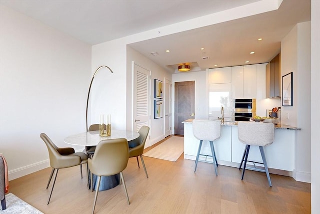 dining area with baseboards, recessed lighting, and light wood-style flooring