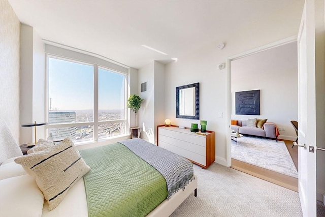 bedroom featuring baseboards, light colored carpet, and visible vents